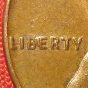 1997 BIE error penny close-up showing raised die gouge between B and E in the word LIBERTY resembling the letter I